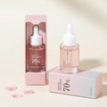 Peach 70% Niacin serum bottle and packaging on a light background with pink petals.